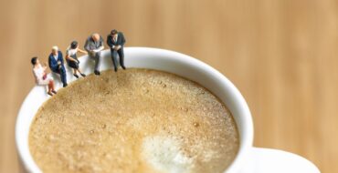 Pausa para o café no trabalho representada com pessoas sentadas dentro de xícaras.