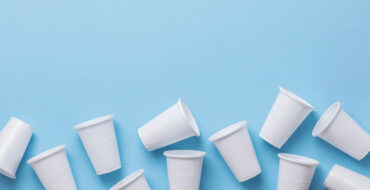 Copos plásticos brancos sobre fundo azul, ideais como produtos descartáveis