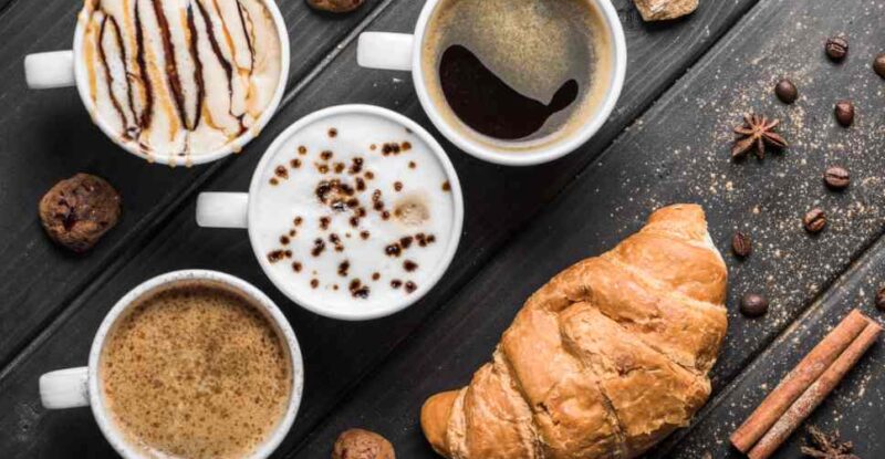 Xícaras de café e um croissant ilustram o desperdício no coffee break.